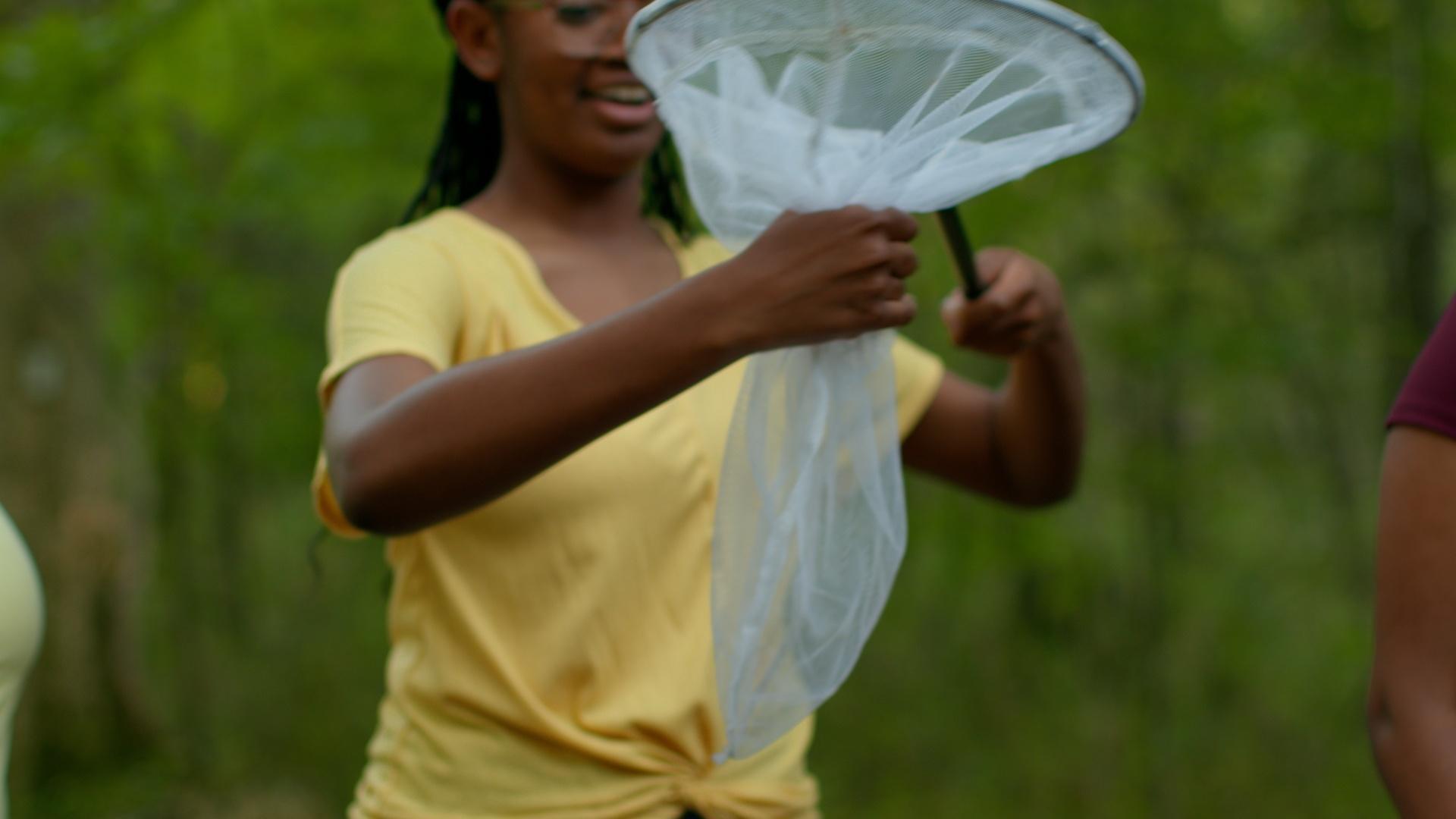 The SciGirls help Orit safely catch fireflies for her research.
