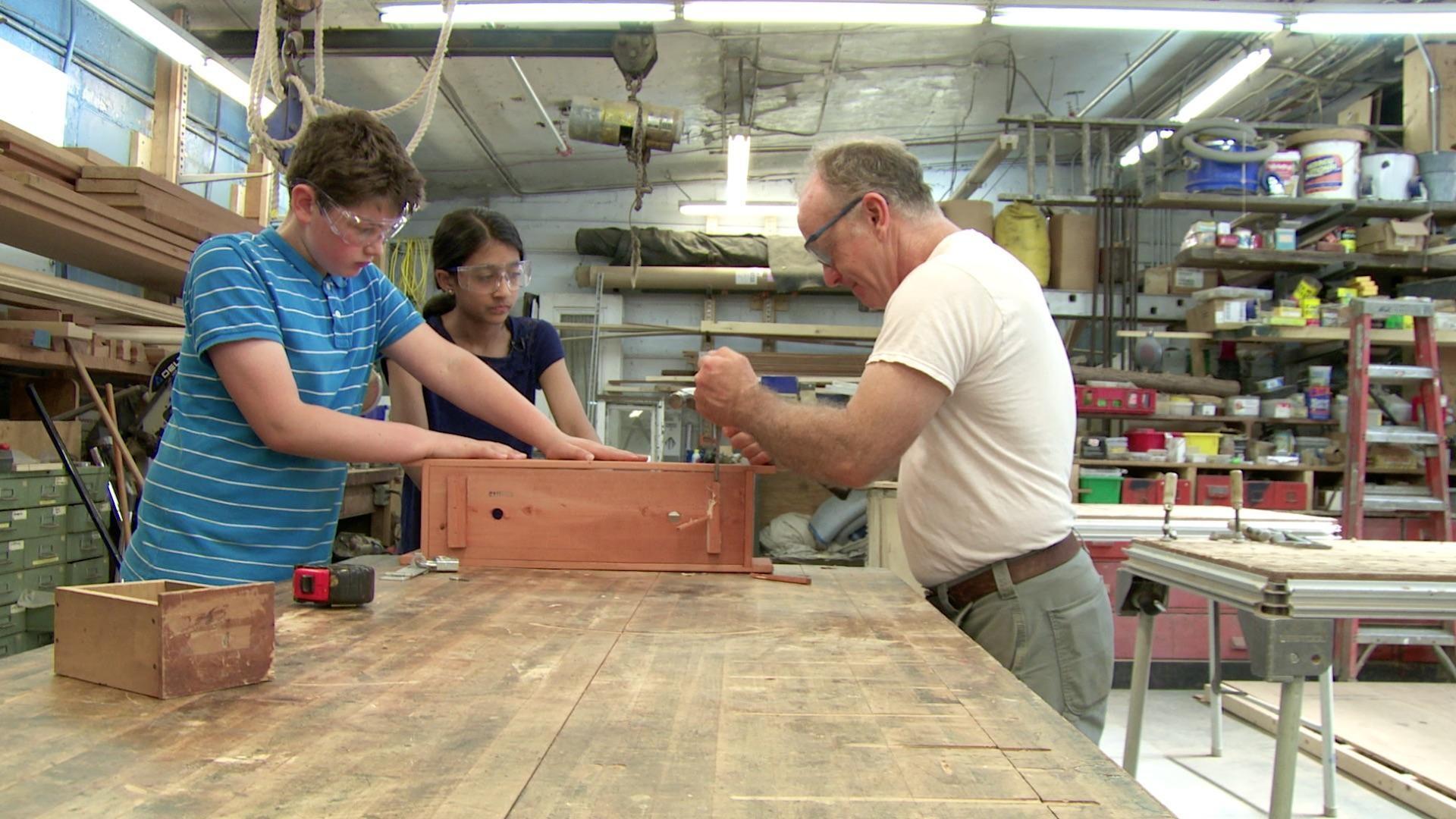 Anjali and Caleb build a strong and secure box to collect money for an arts center.