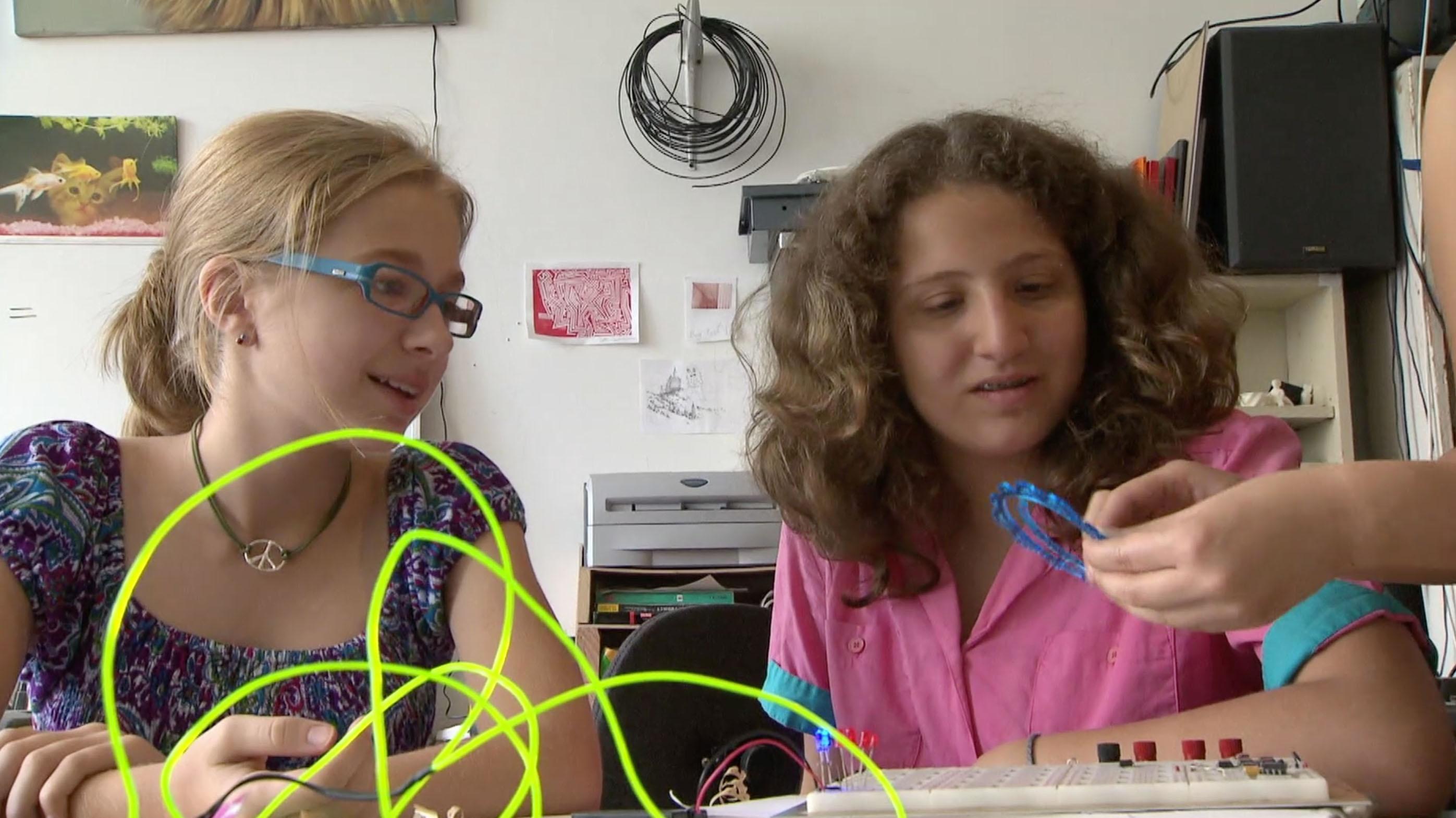 The SciGirls experiment with the laser cutter.