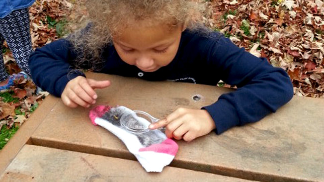 Girl examines sock at table